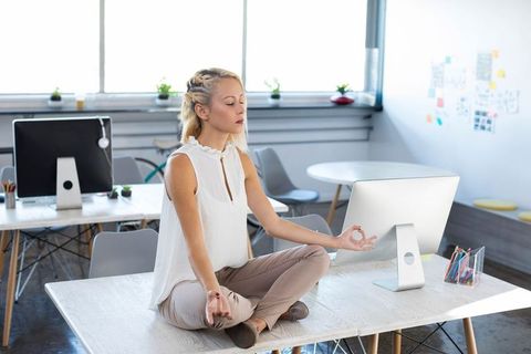Businesswoman Practicing Meditation at Modern Office Workspace