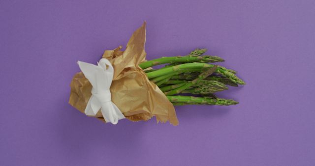 Fresh Asparagus Bundle with Brown Paper and Ribbon on Purple Background - Download Free Stock Images Pikwizard.com