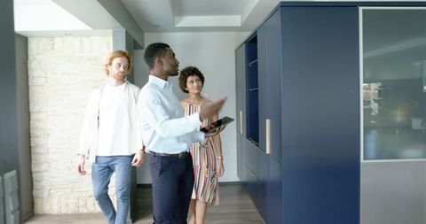 Real estate agent showing modern apartment to couple