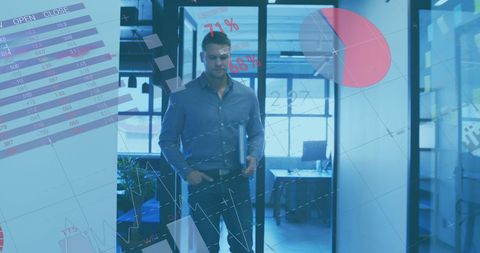 Businessman amidst holographic financial projections in modern office