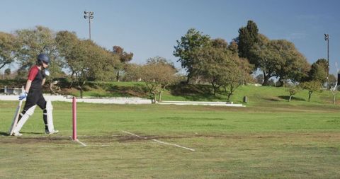 Cricket Player Walking on Field During Sunny Day