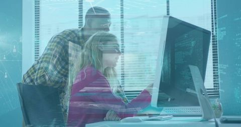 Collaborating Engineers Analyzing Code on Monitor in Tech Office