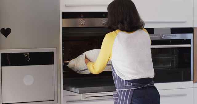 Image of happy asian woman taking out cake from oven. Lifestyle and spending time at home concept.