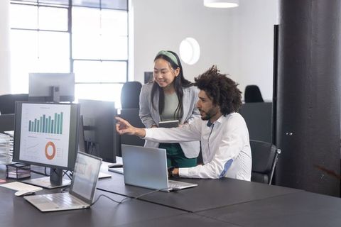 Diverse Coworkers Collaborating on Business Data in Modern Office