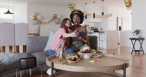 Happy Couple Taking Selfie at Birthday Celebration with Snacks at Modern Living Room
