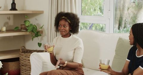 Women Enjoying Refreshing Drinks and Sharing Moments at Home