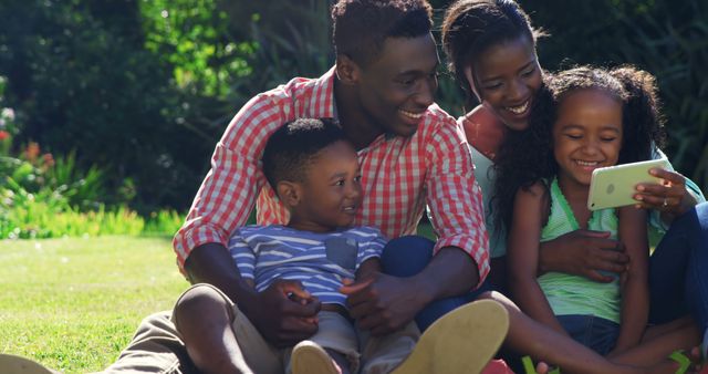 Happy Family Relaxing Outdoors and Using Smartphone Together - Download Free Stock Images Pikwizard.com