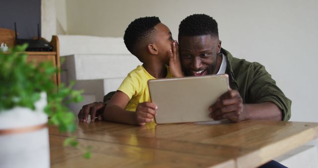 Father and Son Sharing a Secret while Using Tablet at Home - Download Free Stock Images Pikwizard.com