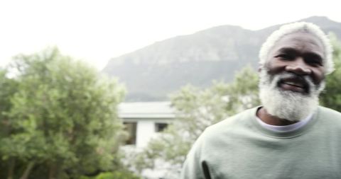 Smiling Senior Man Enjoying Tranquil Outdoors Near Mountain
