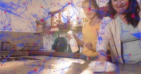 Mother and daughter cleaning kitchen countertop together, wiping and spraying for sparkle