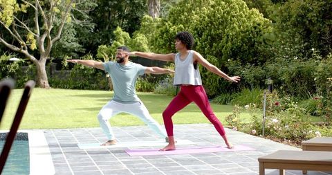Couple Practicing Yoga Outdoors for Health and Wellbeing