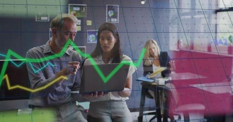 Business professionals analyzing data on laptop with graph overlay
