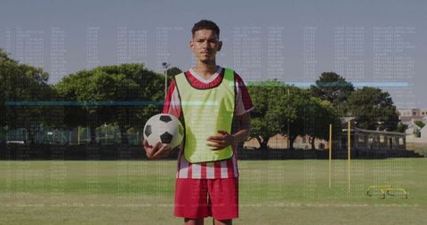 Soccer player in training field holding soccer ball