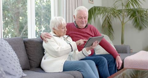 Senior Couple Embracing Technology on Sofa at Home - Download Free Stock Images Pikwizard.com