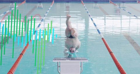 Swimmer executing headfirst start from starting block in indoor pool with data overlay