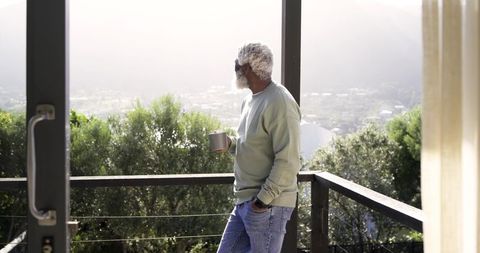 Senior Man Relaxing on Balcony Enjoying Scenic View