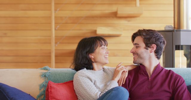 Couple enjoying a moment of togetherness and relaxation in a cozy cabin. Perfect for use in promotions related to relationships, lifestyle, home leisure, vacation rentals, and intimate moments. Captures the warmth and comfort of spending quality time with a loved one.