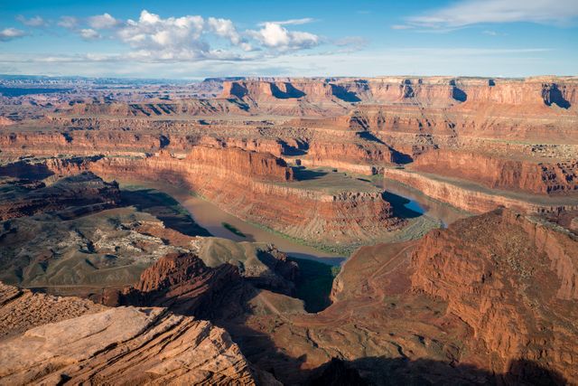 Panoramic view of Dead Horse Point State Park showing dramatic red rock canyons carved by the Colorado River. Ideal for promoting travel, outdoor adventures, nature exploration, and tourism in Utah. Suitable for use in websites, travel brochures, and environmental campaigns.