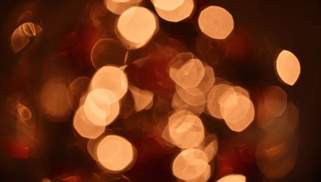 Glowing amber bokeh with hexagonal aperture highlights creating warm abstract background