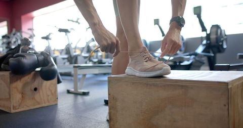 Athlete Tying Shoelaces in Gym Before Workout Routine