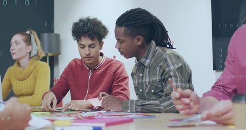 Young adults collaborating on colorful paper craft project in classroom workshop