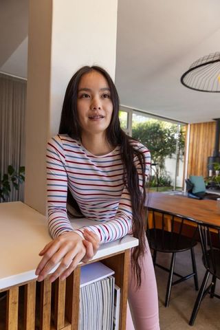 Braced woman relaxing in modern open-plan kitchen