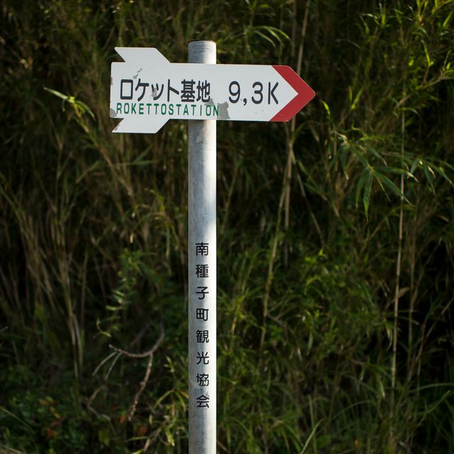 Photo shows a direction sign guiding travelers to Tanegashima Space Center on Tanegashima Island in Japan. The sign includes Japanese text and an indication of 9.3 kilometers to the rocket station. Ideal for travel guides, space exploration articles, and educational content related to JAXA and NASA's joint Global Precipitation Measurement mission. Great for illustrating directions or travel experiences in Japan.