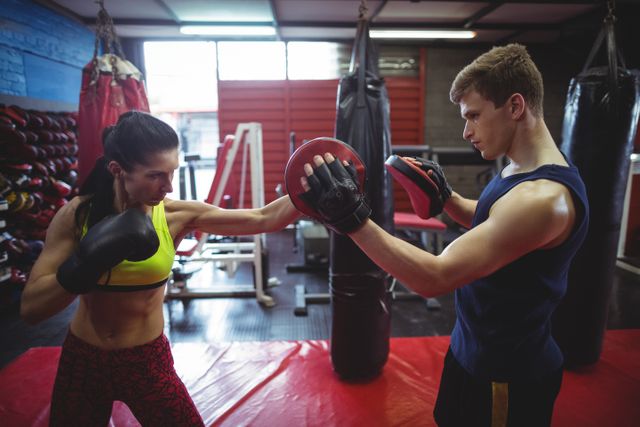 Boxers using focus mitts during training in fitness studio