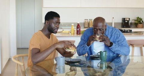 African American Father and Son Dining Together in Modern Kitchen