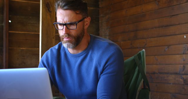 Focused Man Working on Laptop in Cozy Wooden Interior - Download Free Stock Images Pikwizard.com