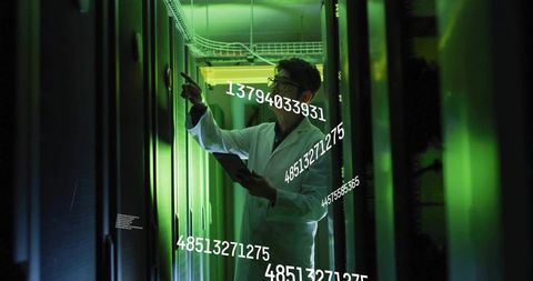 IT Engineer Inspecting Server Rack in Futuristic Green Data Center with Tablet Holographic Overlays