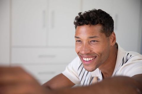 Smiling man leaning forward near closet in home office
