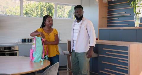 Family preparing for school in modern kitchen setting