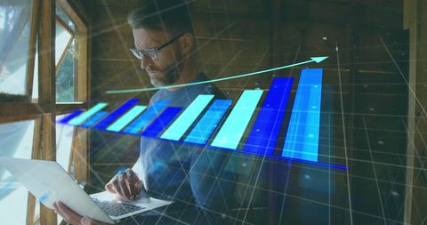 Man analyzing data on laptop with upward business graph overlay