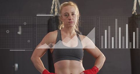 Female boxer standing confident with red hand wraps and performance data overlays