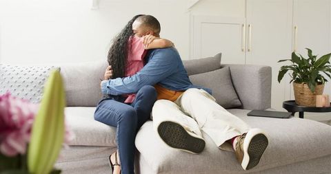 Couple Embracing joyously after Pregnancy Announcement on Sofa