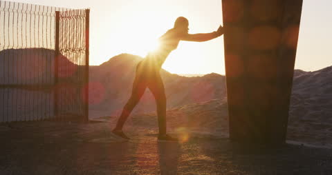 Silhouette of Man Stretching Against Sunset by Sea