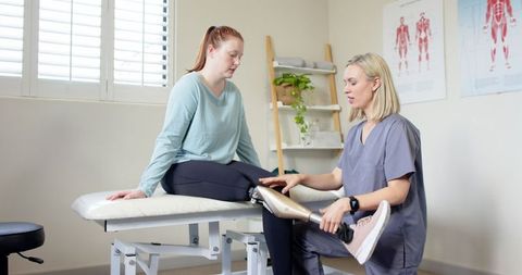 Physical therapist adjusting prosthetic leg during rehabilitation session