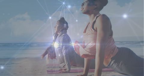Women Practicing Yoga at Beach with Digital Light Overlay