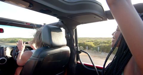 Friends Enjoy Convertible Road Trip Adventure at Sunset