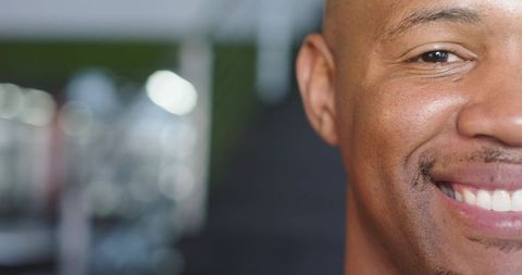 African American man smiling closeup at gym with bokeh background and confident energy