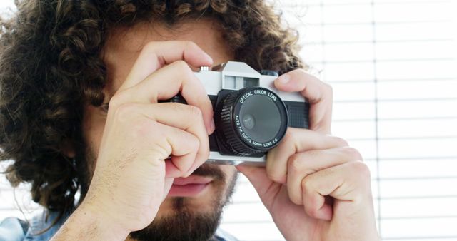 Man with Curly Hair Using Vintage Film Camera - Download Free Stock Images Pikwizard.com