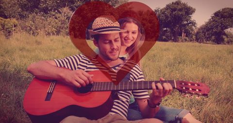 Romantic Couple Outdoors with Guitar and Heart Overlay