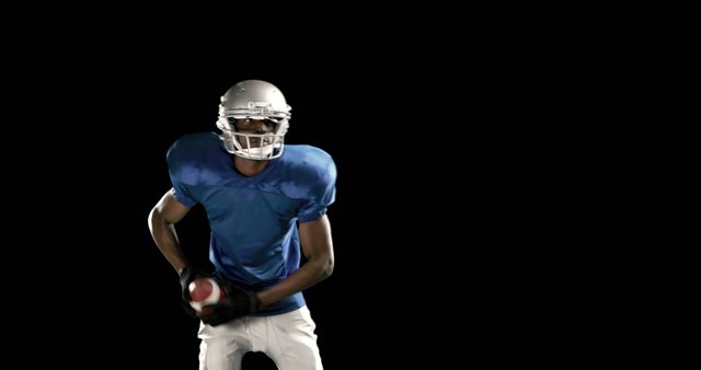 American Football Player Holding Ball in Black Background - Download Free Stock Images Pikwizard.com