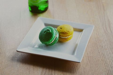 Colorful macarons on elegant white plate with wooden background