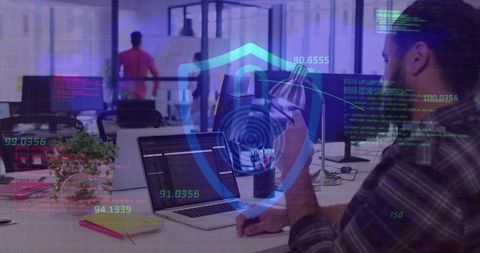 Developer reviewing code with digital security interface in office