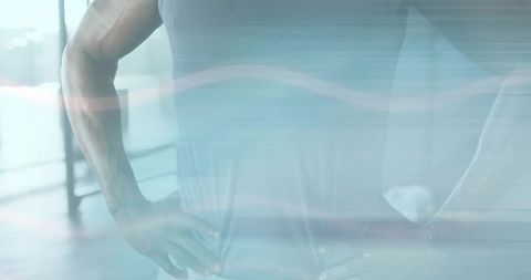 Muscular torso in fitness gym with window reflection