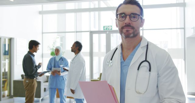 Confident Doctor Holding File in Hospital Corridor - Download Free Stock Images Pikwizard.com