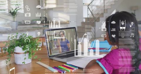 Young student studying remotely from home on laptop with headphones, colorful pencils and notebook