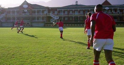 Rugby Team Practicing Passing on Sunny Club Field with Foreground Catch